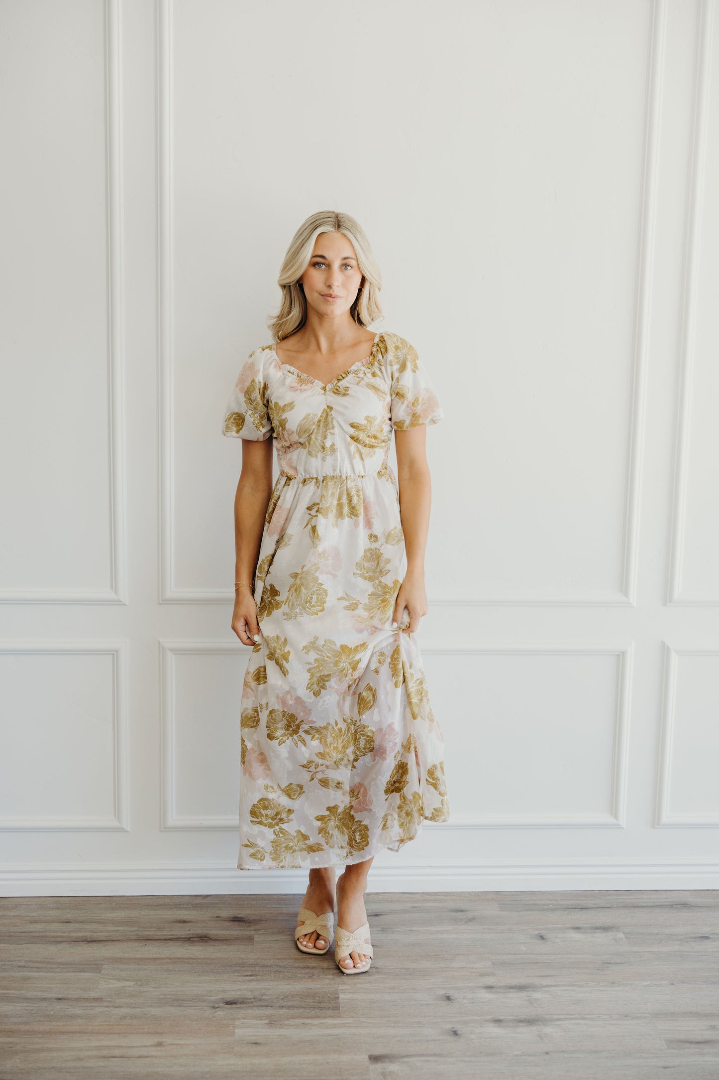 Midi length light pink and olive print dress with natural waistline and v neckline.