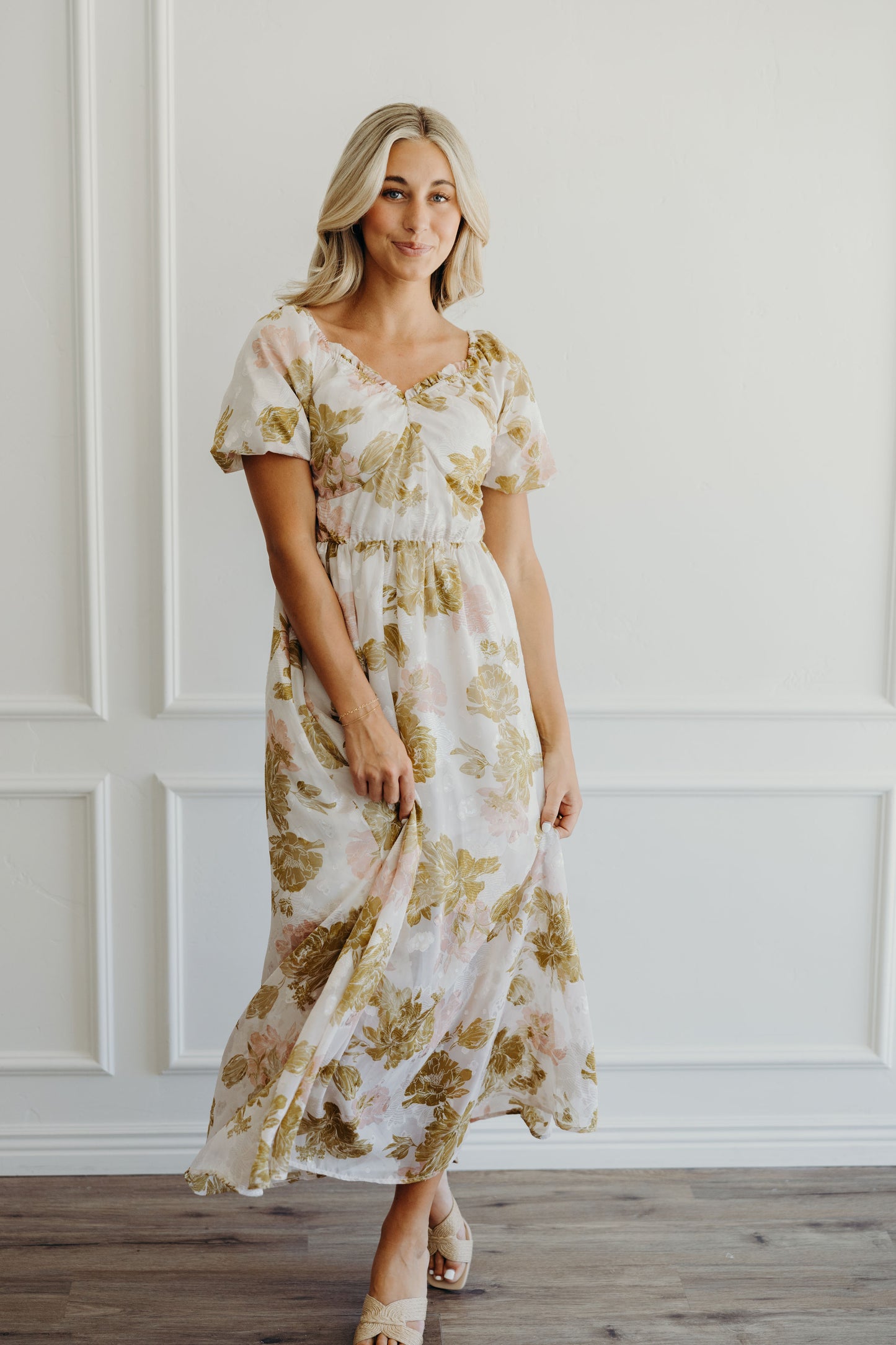 Midi length fit and flare pink and olive print dress with short puff sleeves an sweetheart neckline.