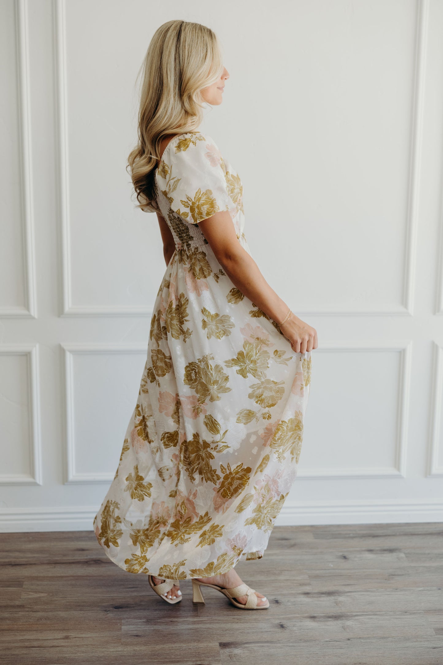 Side view of pink and olive print dress with short sleeves.