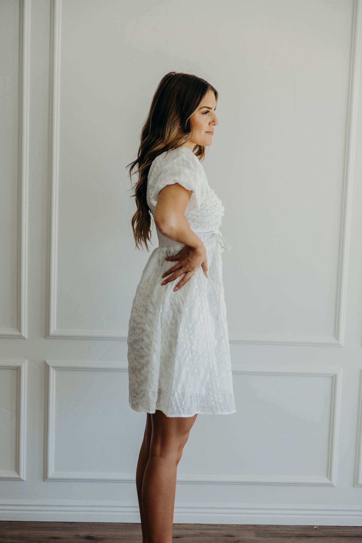 Short white textured dress with short puff sleeves.