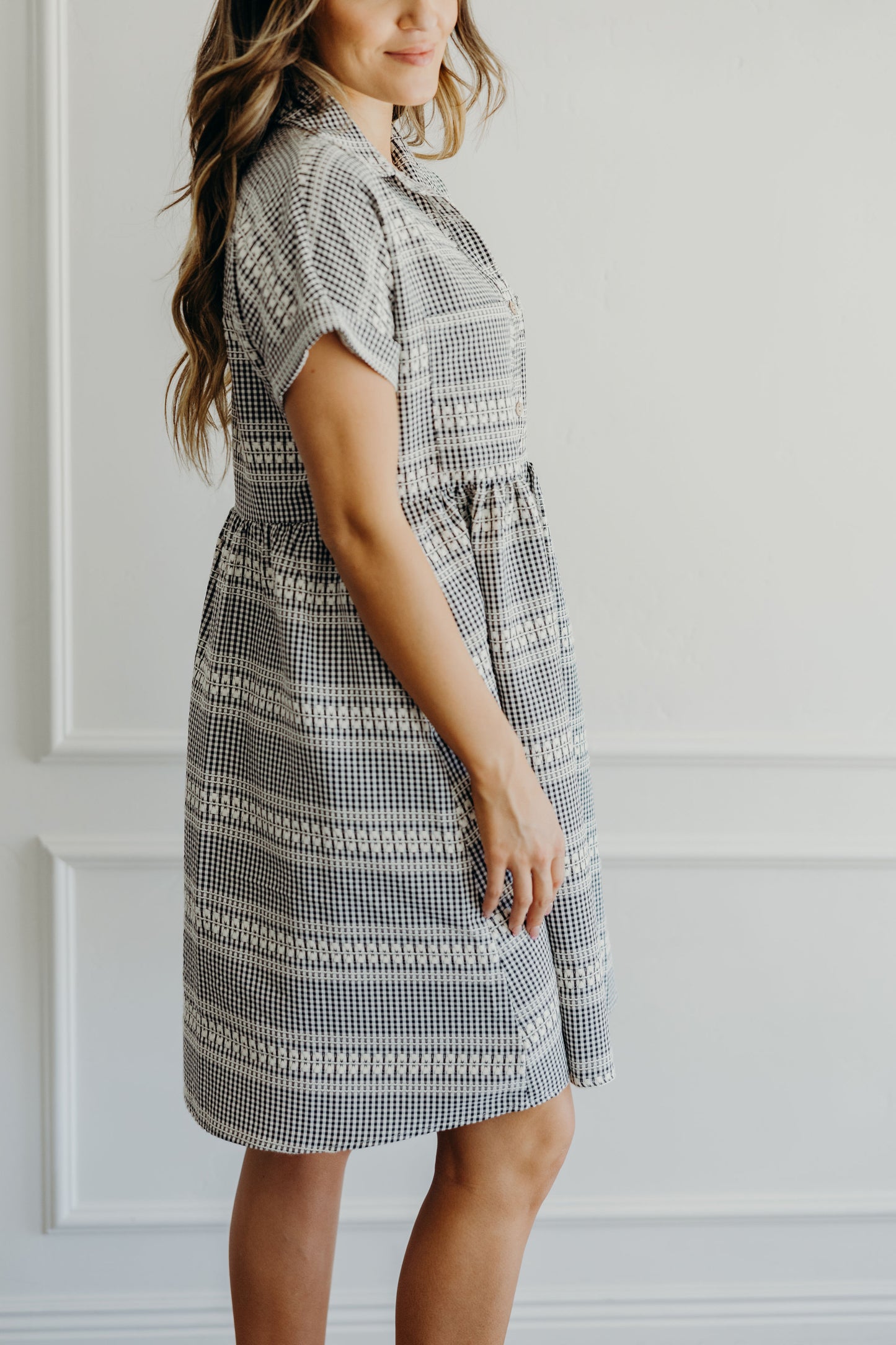 Detail shot of cream and black checkered short sleeve dress.