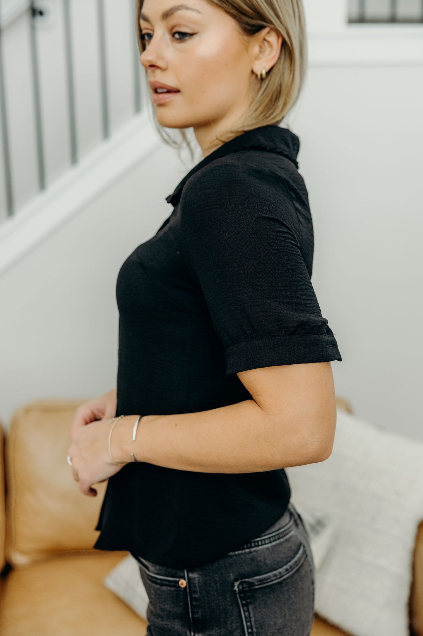Black blouse with button detail on sleeve.