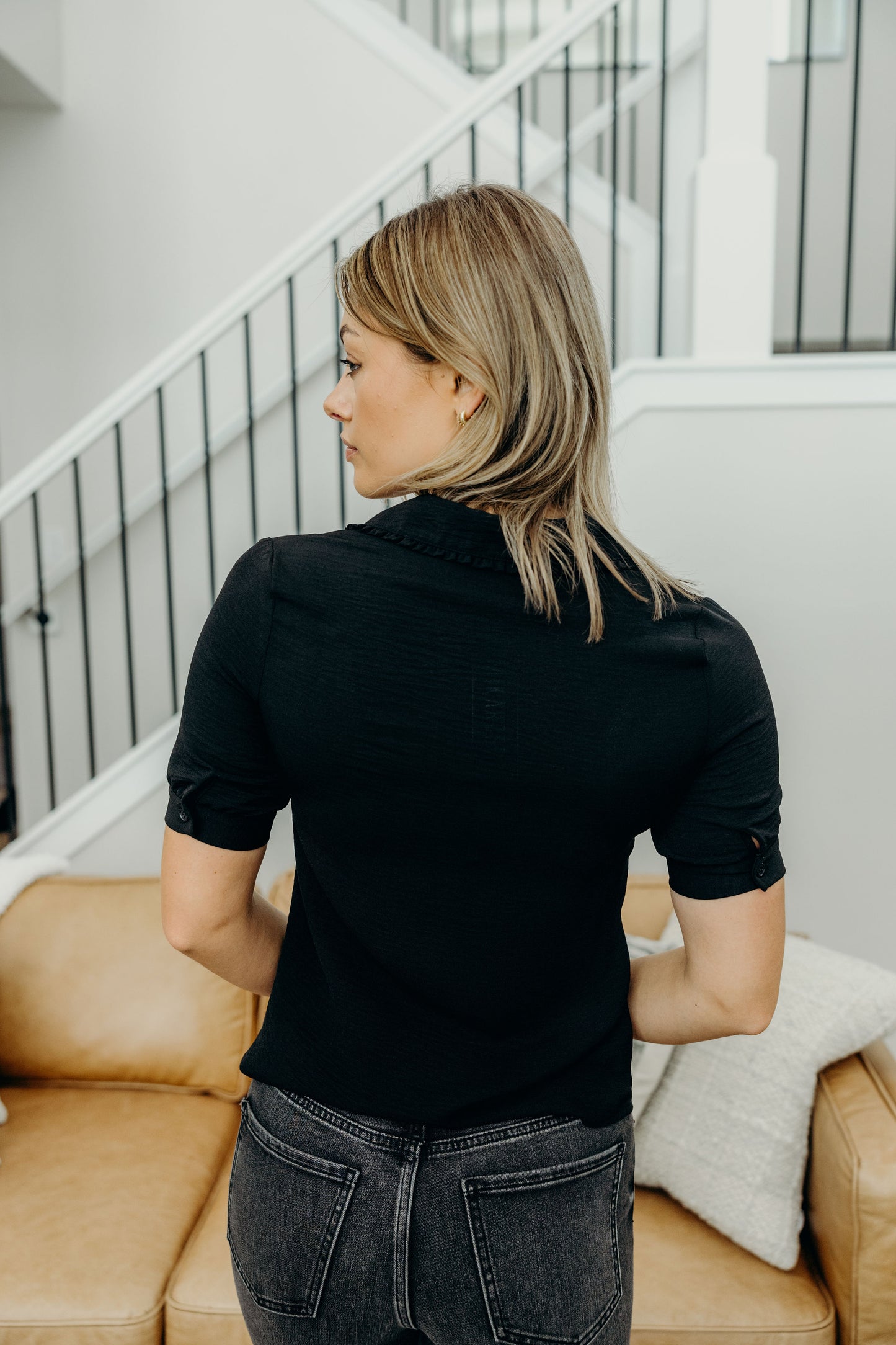 Black collared blouse with short puff sleeves.