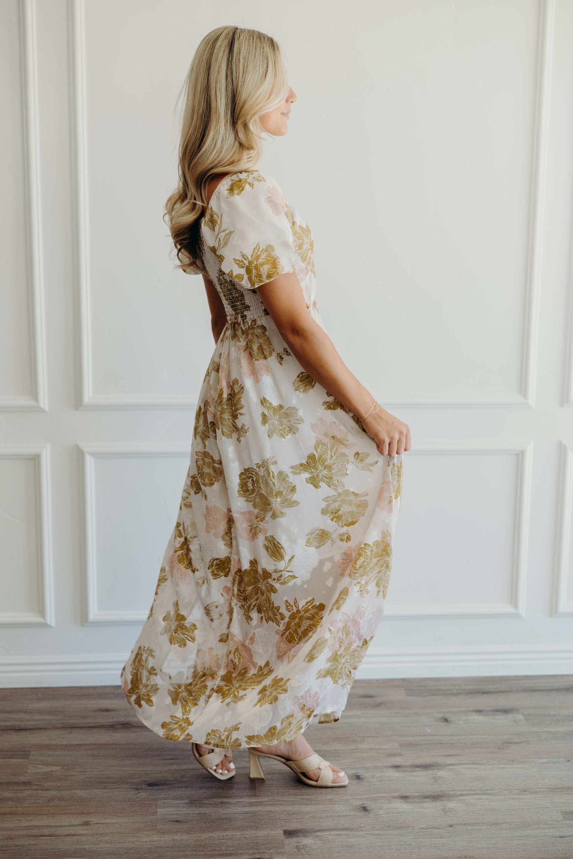 Side view of pink and olive print dress with short sleeves.