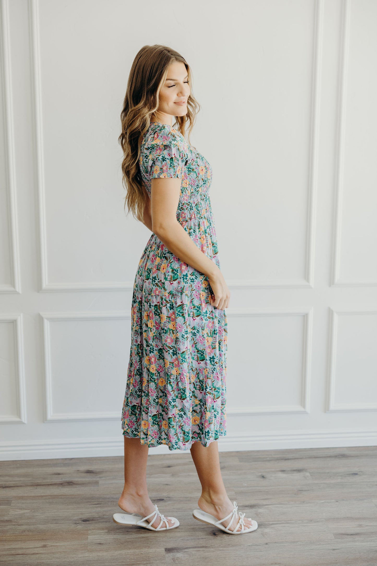 Side view of green and yellow floral print dress with fit and flare silhouette and short sleeves.