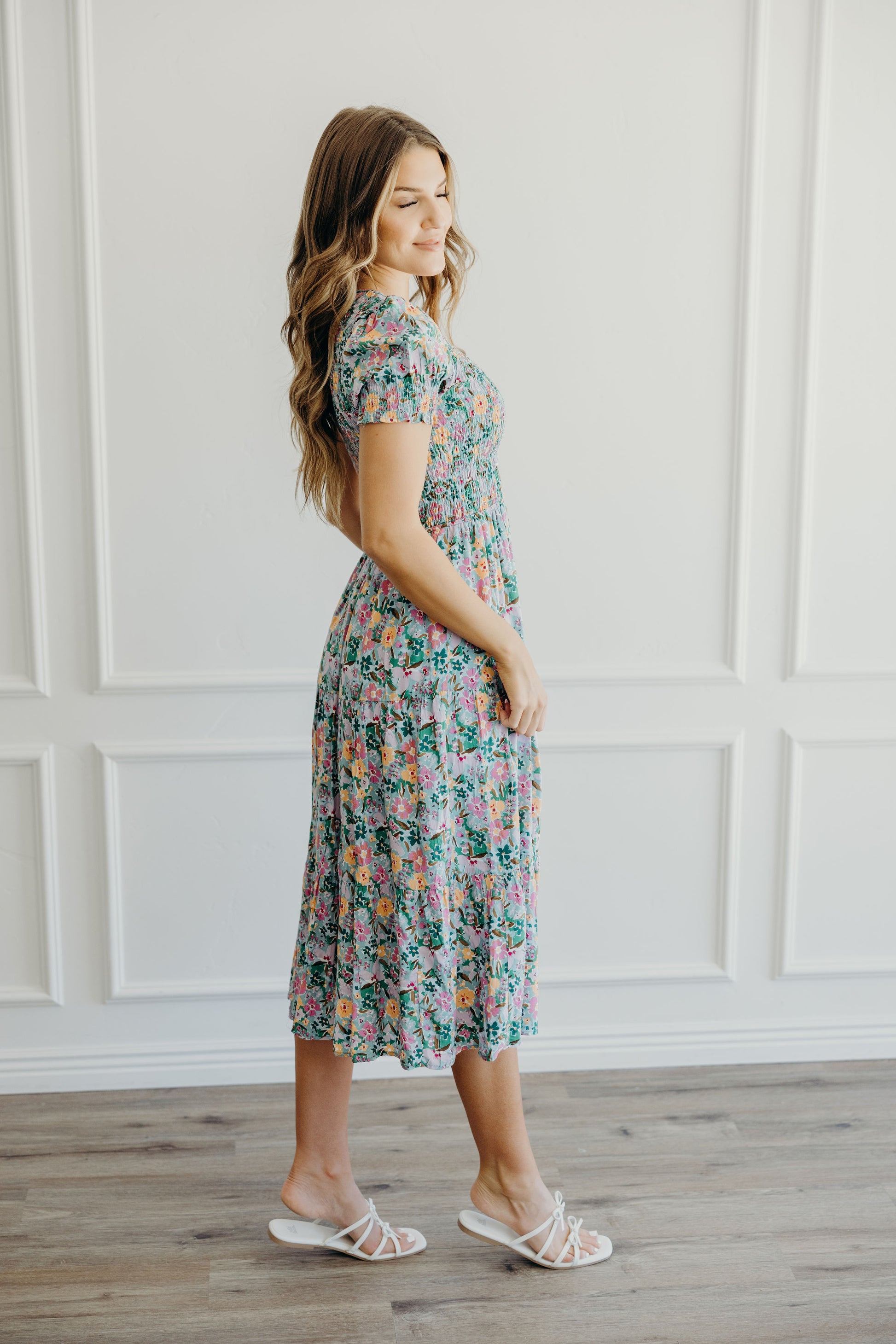 Side view of green and yellow floral print dress with fit and flare silhouette and short sleeves.