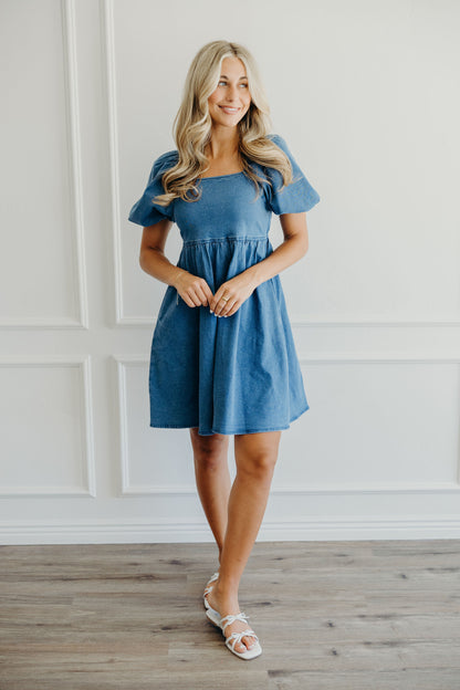 Denim dress with empire waist and puff sleeves.