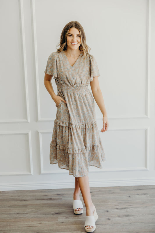 Midi length dress with fit and flair silhouette, tiered skirt with ruffle detail, smocked natural waist, and faux wrap detail.