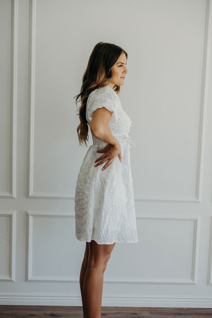 Short white textured dress with short puff sleeves.