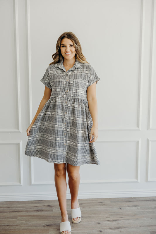 Knee length textured checkered dress with natural waistline, button and collar detail.