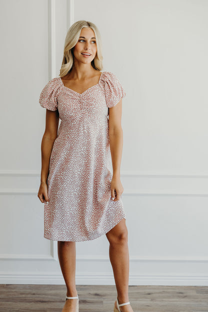 Knee length pink floral print dress with empire waistline, sweetheart neckline and short puff sleeves.