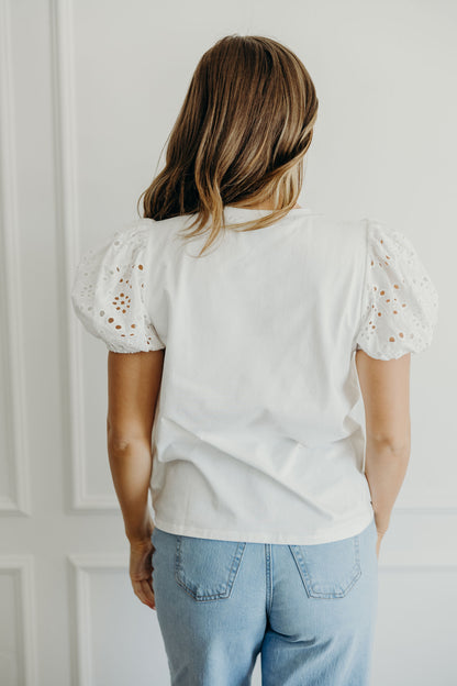 Back view of white eyelet shirt with puff sleeves.