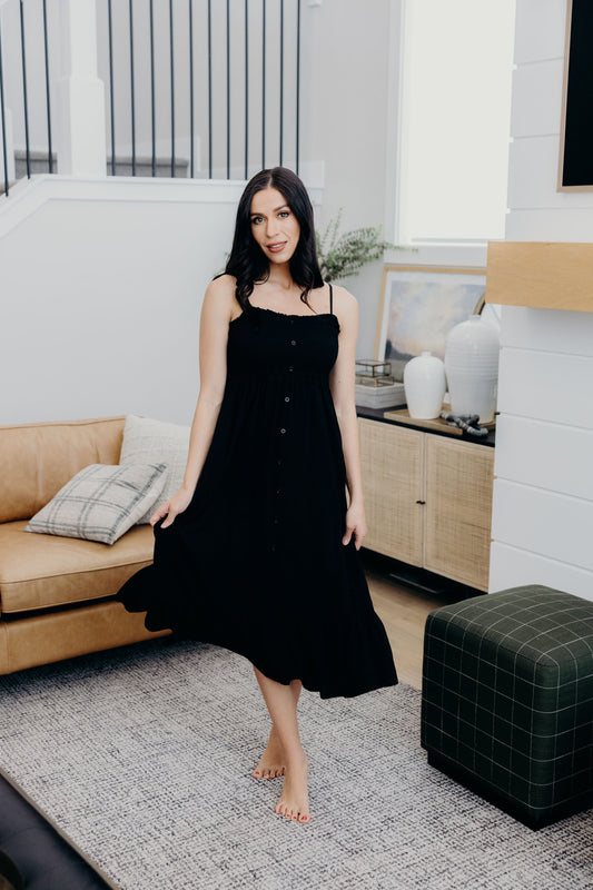 Black fit and flare dress tank dress with ruffle hem, smocked bodice, and button detail.
