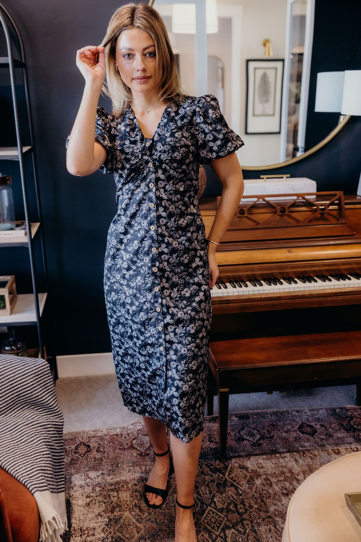 Black floral print dress with button down detail, v neckline, and short sleeves.