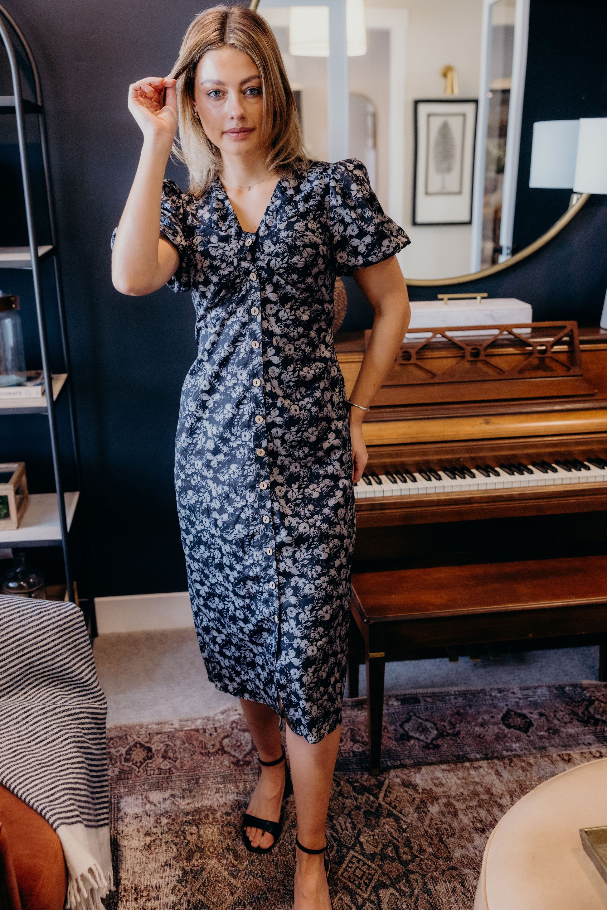 Black floral print dress with button down detail, v neckline, and short sleeves.