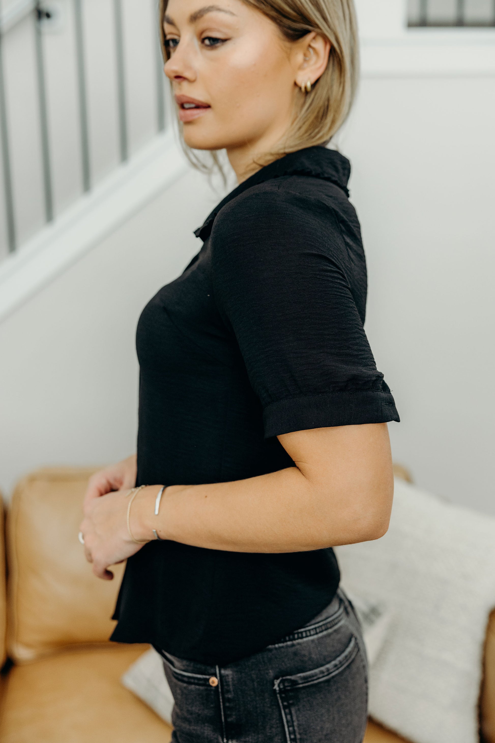 Black blouse with button detail on sleeve.